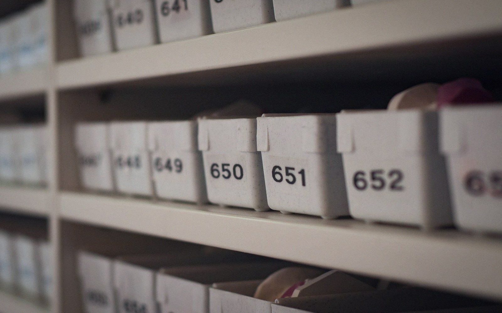 Numbered storage boxes lined up on shelves in a filing archive