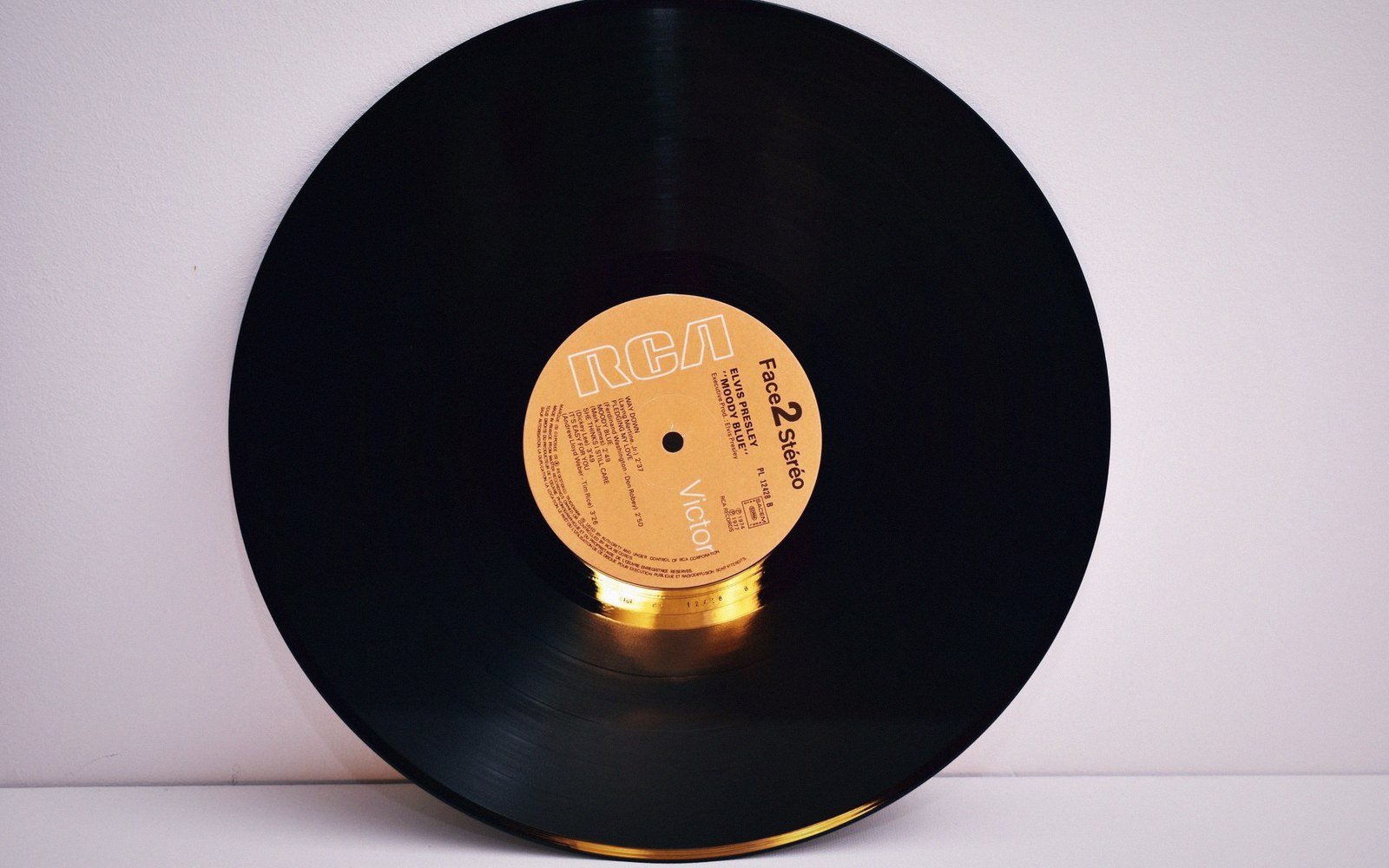 A vinyl record leaning against a wall, showing its gold RCA Victor label